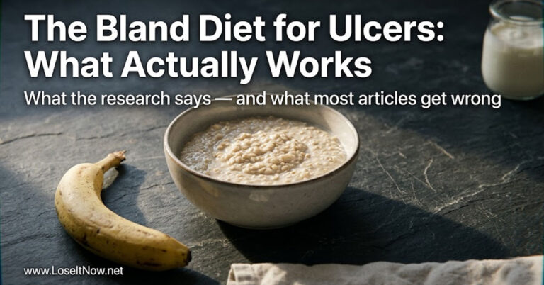 A ceramic bowl of oat porridge and banana on slate — foods recommended in a bland food diet for ulcers, photographed in cool natural morning light.